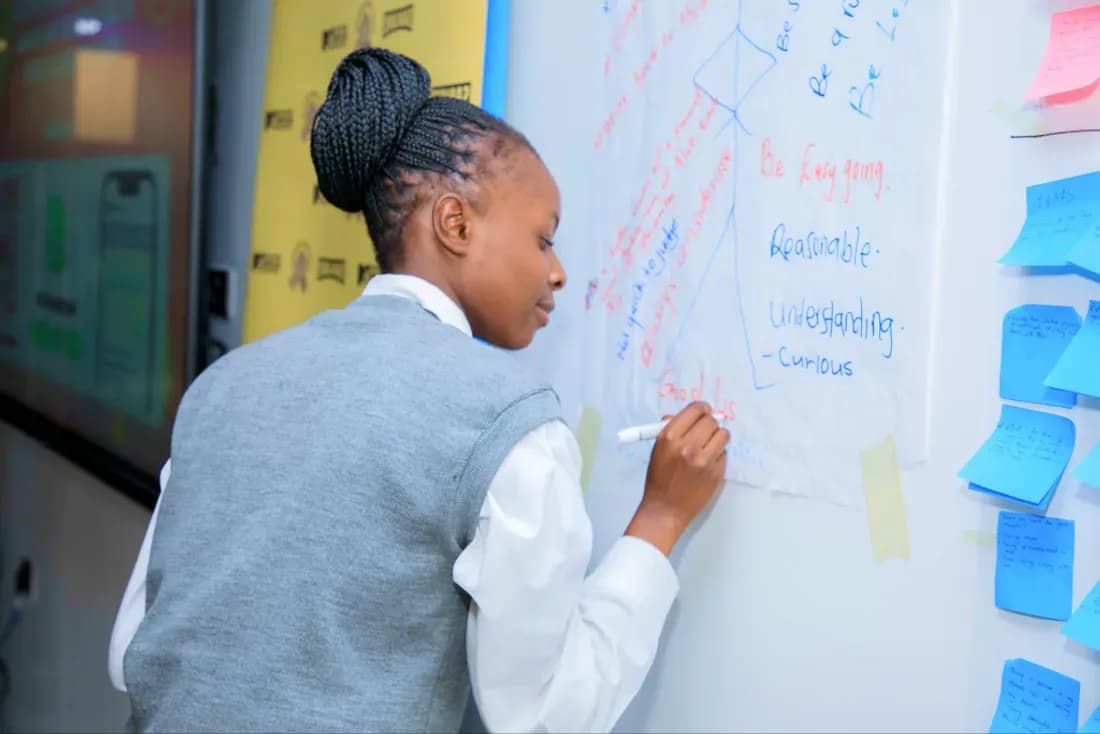 A student writing reflections on a whiteboard