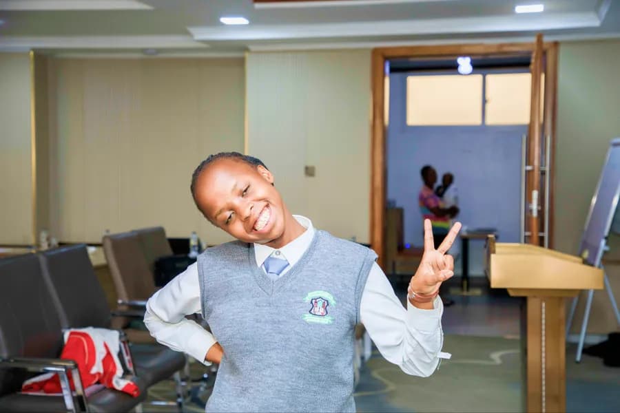 A smiling schoolboy giving a peace sign